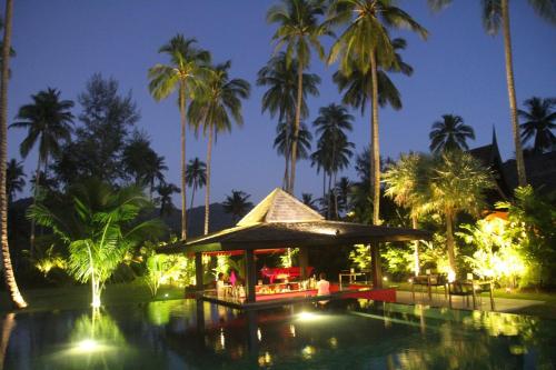 a resort with a pool and palm trees at night at Siam Royal View Villas in Ko Chang