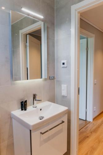 a bathroom with a white sink and a mirror at Förstklassig bekvämlighet! in Jönköping