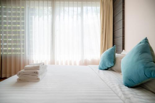 a white bed with blue pillows and towels on it at Patong Kalim Unparalleled Sea View B&B Resort in Patong Beach
