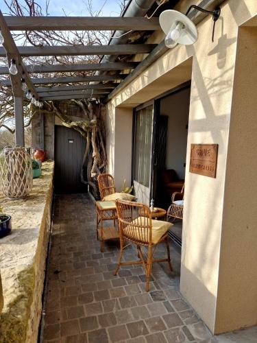 d'une terrasse avec des chaises, une table et un panneau. dans l'établissement L'atelier du Doubs, à Verdun-sur-le-Doubs