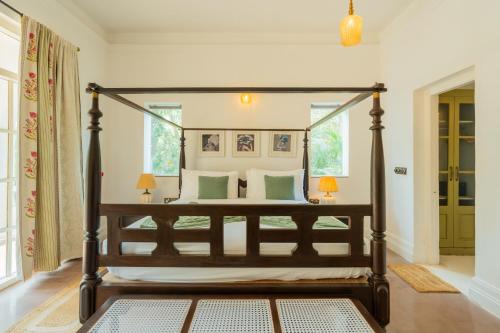 a bedroom with a canopy bed in a room at ELIVAAS Maison 10 - Luxe 4 BHK Villa With Pvt Pool, Garden & Portuguese Charm in Siolim
