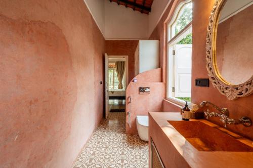 a bathroom with a sink and a mirror at ELIVAAS Maison 10 - Luxe 4 BHK Villa With Pvt Pool, Garden & Portuguese Charm in Siolim