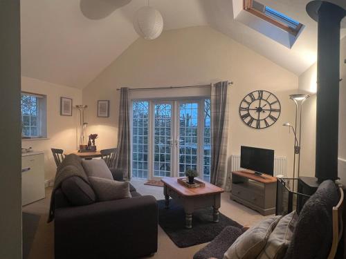 a living room with a couch and a tv at Ashbourne Cottage in Ringwood