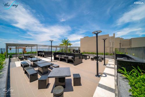 a patio with tables and benches on a building at Cloud Nine The Song Vung Tau Homestay in Vung Tau