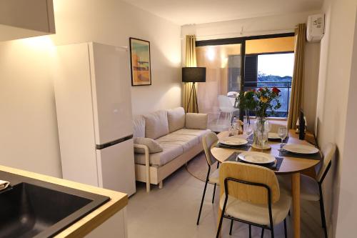 Il dispose d'une cuisine et d'un salon avec une table et un réfrigérateur. dans l'établissement T2 Charme Corse, Piscine, Plage et Vue Mer, à Pianottoli-Caldarello