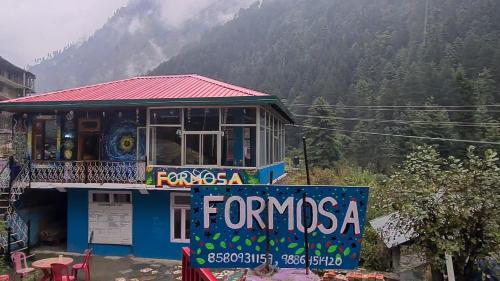 a building with a sign that reads feria fominosa at Formosa cafe & hostel in Kasol