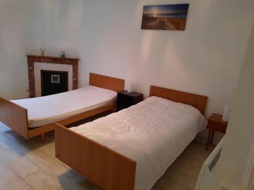 une chambre avec deux lits et un tableau au mur dans l'établissement Aux portes de nancy , studio avec parking gratuit, à Frouard