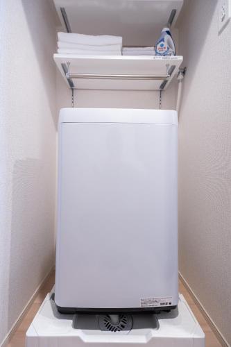 a white refrigerator freezer sitting in a room at KINSHICHO Tokyo Holiday Hotel in Tokyo