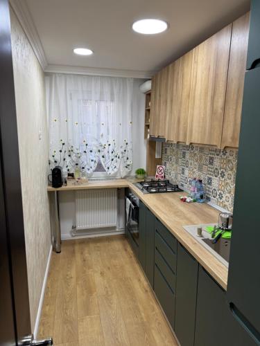 a kitchen with wooden cabinets and a counter top at Apartament Narcisa in Bacău