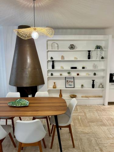 une salle à manger avec une table et une étagère avec des vases dans l'établissement 102 - Terrasse de la Bastide, à Carcassonne