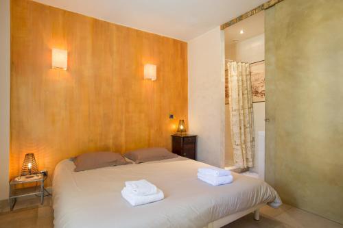 a bedroom with a bed with two towels on it at La Maison de Maître, la plus grande des 3 maisons du Clos d'Isand'Or in Meursault