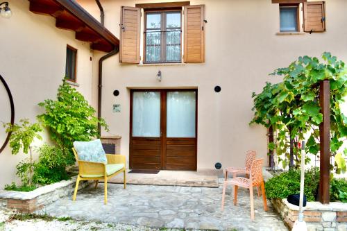 a pair of chairs sitting outside of a house at Agriturismo Colle Mura in Morano Madonnuccia