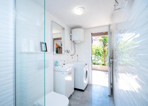 a bathroom with a toilet and a sink and a shower at Historic Stone Home On The Seafront With King Beds And Garden in Stari Grad