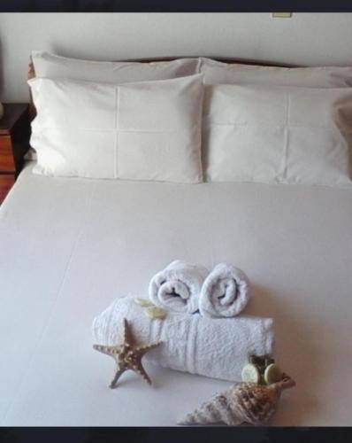 a white bed with towels and a starfish on it at Rena Apartments Vasilikos Zante in Xirokástellon