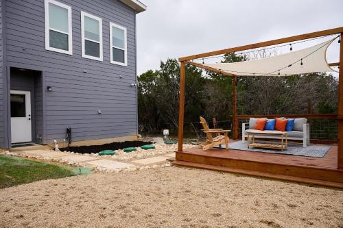 a deck with a bench and an umbrella next to a house at A Stunning Escape in Canyon Lake