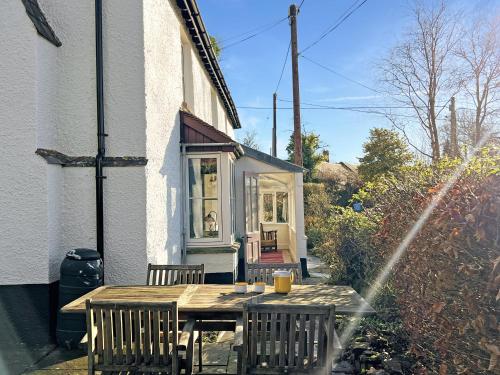 a wooden table and chairs outside of a house at Hare and Hounds Exton in Exton