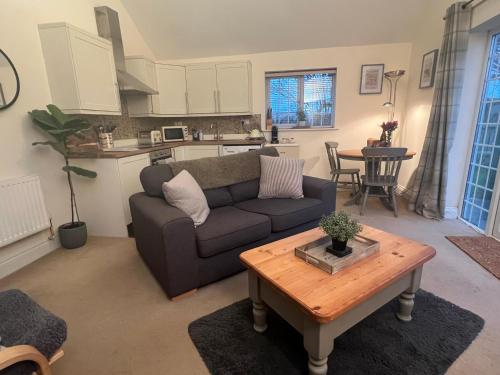 a living room with a couch and a table at Ashbourne Cottage in Ringwood