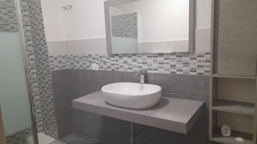 a bathroom with a white sink and a mirror at I Faraglioni Comfort Rooms in Terrasini