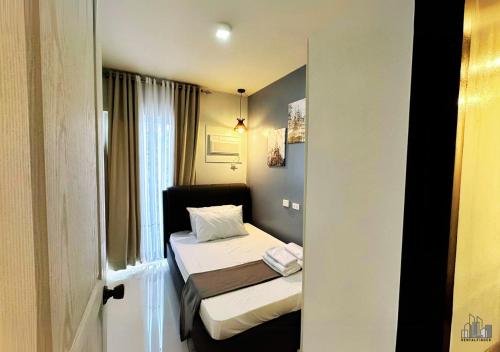 a small room with two beds and a window at Palawan Luxury 2BR Condo with Pool, Gym & Parking - B1 5Kunzite in Puerto Princesa City