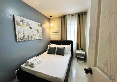 a small bedroom with a bed in a room at Palawan Luxury 2BR Condo with Pool, Gym & Parking - B1 5Kunzite in Puerto Princesa City