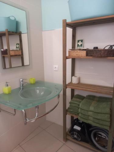 a bathroom with a sink and a mirror and towels at Vilas Horizonte in Porto Santo