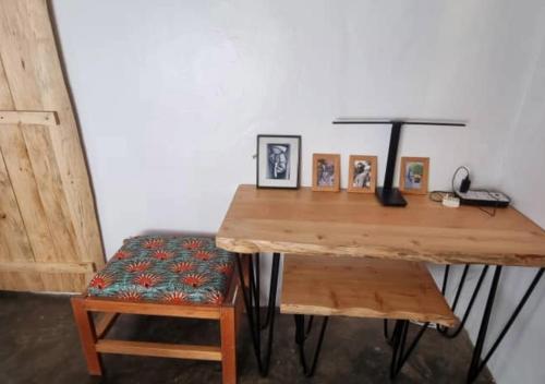 a wooden desk with a chair and pictures on it at Mutolere Coffee Pot Guest Houses in Kisoro