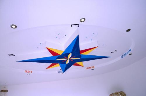 a ceiling painting of a star on a ceiling at La Dimora le Fumarole Rooms in Ercolano