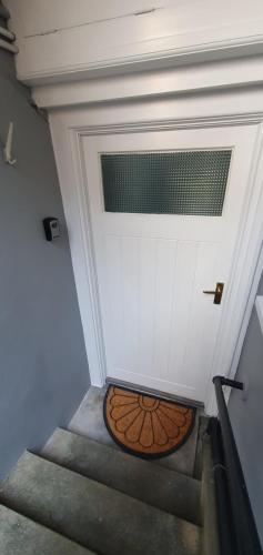 a white garage door with a metal door mat in front at Ivy's in Grange Over Sands