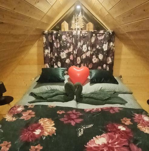 a bed with a red heart on top of it at Faház a fenyők alatt - Borostyánkút Wellness Home II Bakonybél in Bakonybél