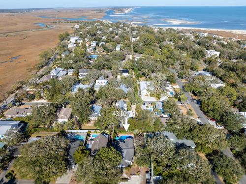 an aerial view of a resort with trees and the ocean at Sunshine Daydreams - 4310 Seventh Street in Saint Simons Island