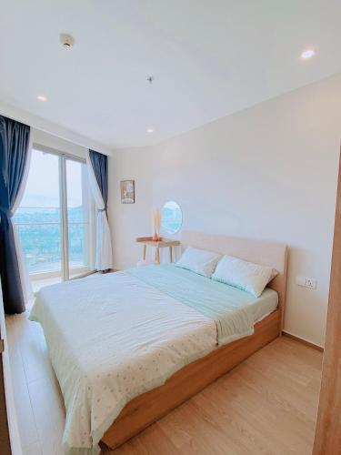 a bedroom with a large bed with a large window at Cloud Nine The Song Vung Tau Homestay in Vung Tau