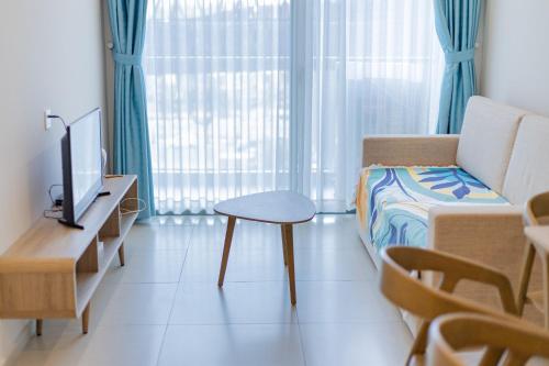 a living room with a couch and a table and a tv at Cloud Nine The Song Vung Tau Homestay in Vung Tau