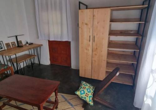 a room with a wooden book shelf and a chair at Mutolere Coffee Pot Guest Houses in Kisoro