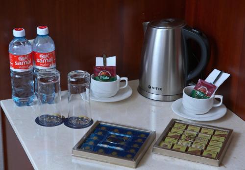 a table with bottles of water and cups on it at Grand Voyage Hotel in Almaty
