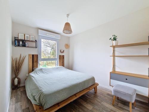 une chambre avec un lit, une chaise et une fenêtre dans l'établissement Maison avec jacuzzi, à Saint-Erblon