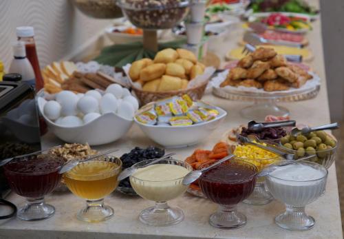 a table topped with bowls of different types of food at Grand Voyage Hotel in Almaty