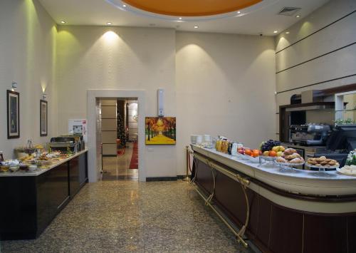 a buffet line in a restaurant with food on display at Grand Voyage Hotel in Almaty