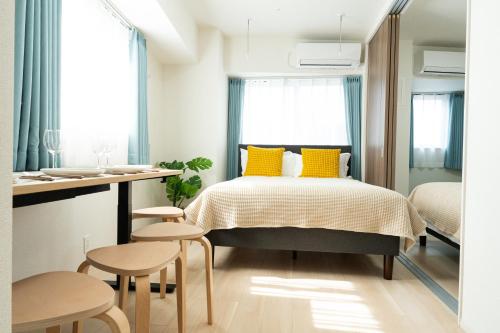a bedroom with a bed with yellow pillows at KINSHICHO Tokyo Holiday Hotel in Tokyo