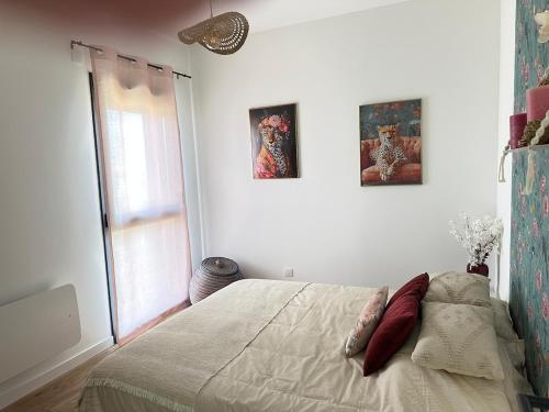 a bedroom with a bed with two pictures on the wall at Le Refuge du Léman, Duplex neuf de 80m 2, à 5 minutes de Geneve pour 4 à 6 personnes in Douvaine