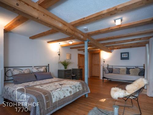 a bedroom with a bed and a chair in a room at 5 Sterne Ferienhaus Gut Stohrerhof am Ammersee in Bayern bis 11 Personen in Dießen am Ammersee