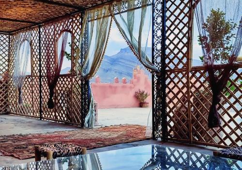 a room with a window with a view of a mountain at Drâa Oasis House Palm Apartment in Ourhiz