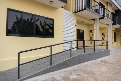 a building with a staircase and windows on it at BOX BOX Hotel and Sports Restaurant in Sattahip