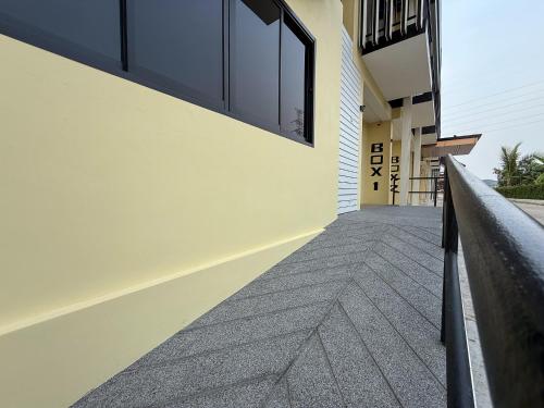 a building with a sidewalk next to a building at BOX BOX Hotel and Sports Restaurant in Sattahip
