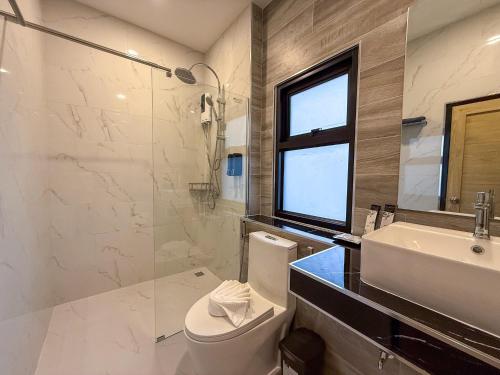 a bathroom with a toilet and a sink and a shower at BOX BOX Hotel and Sports Restaurant in Sattahip