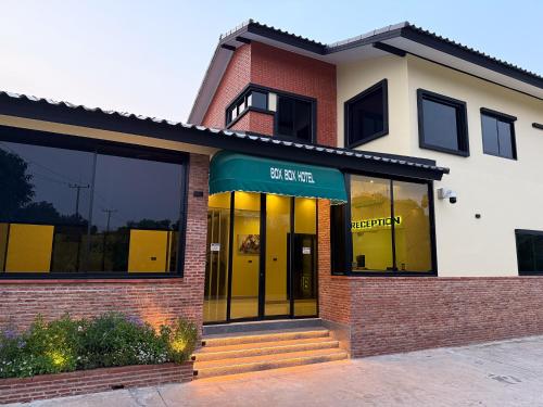 a store front of a brick building with a green awning at BOX BOX Hotel and Sports Restaurant in Sattahip