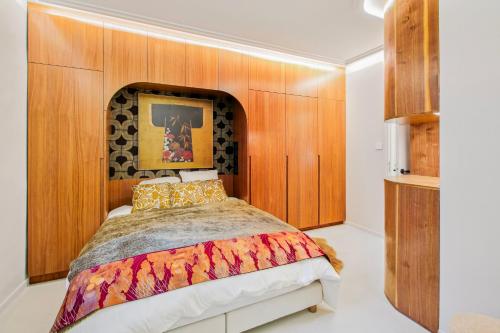 - une chambre avec un lit et un mur en bois dans l'établissement Refined Elegance in Central Paris, à Paris