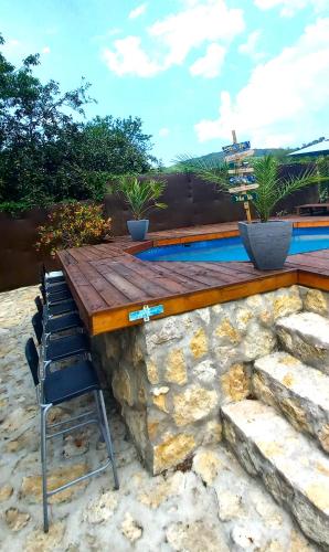 a bar with chairs and a table and some rocks at Faház a fenyők alatt - Borostyánkút Wellness Home II Bakonybél in Bakonybél