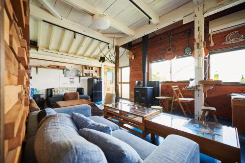 Una sala de estar con sofás azules y una mesa. en GYPSY TAKASHIMA, en Katsuno