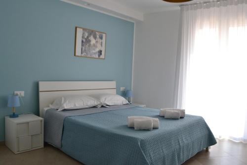 a bedroom with a bed with two towels on it at B&B Sole&Sale in San Leone