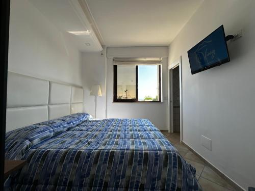 a bedroom with a bed and a window at Re Vincy - Affittacamere in Bacoli